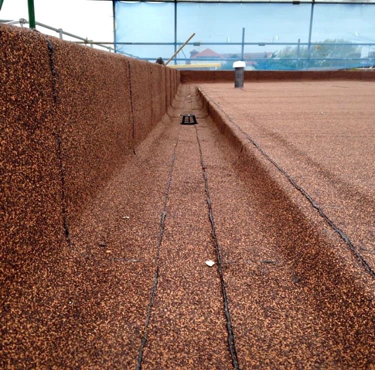Red mineral-felt flat roof detail showing the upstand and central drainage channel